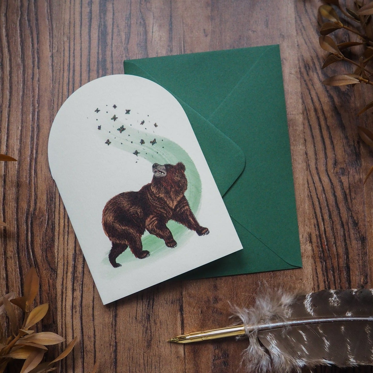 A whimsical bear chasing butterflies on a vintage-style greeting card.