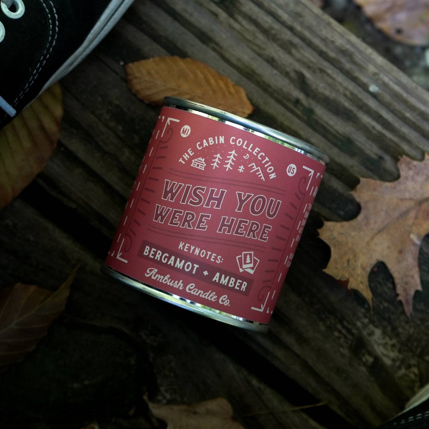 Wish you were here in vintage text across a red tin candle with keynotes of Bergamot and Amber