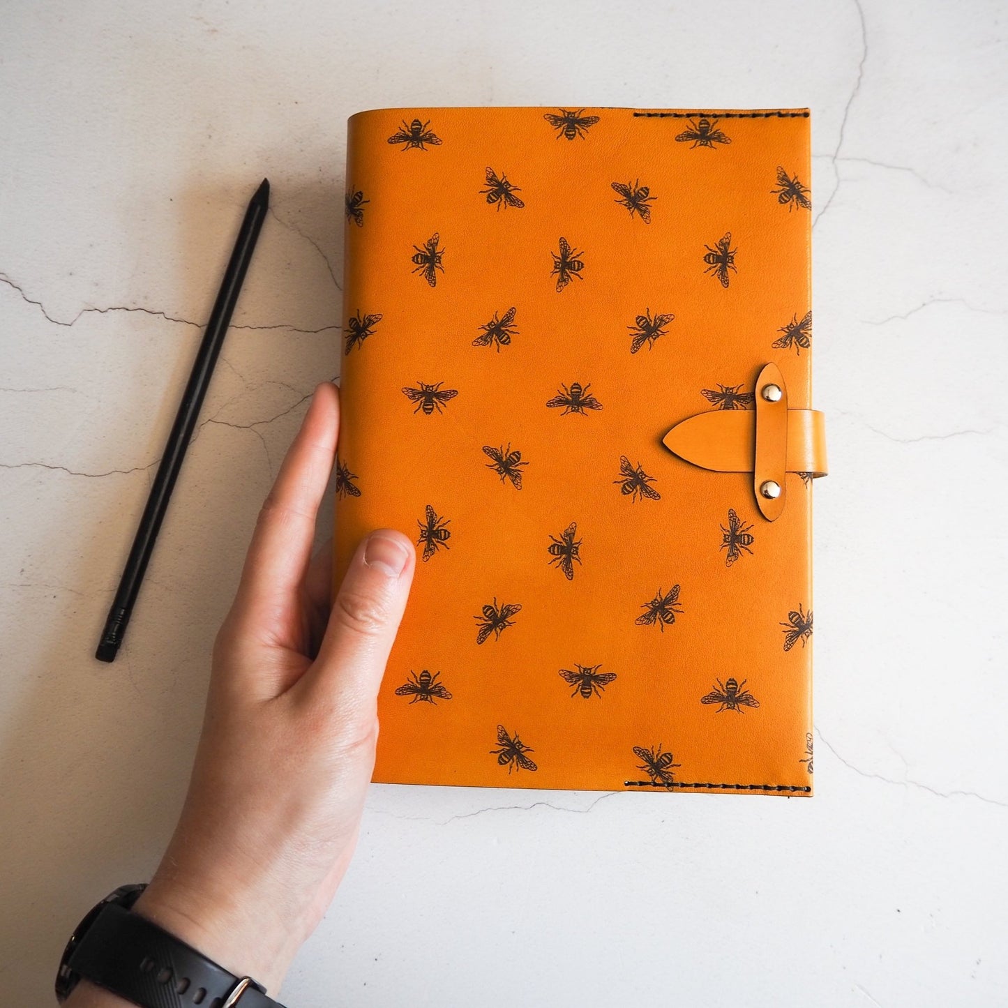 A person holding the Bee Journal by HÔRD.