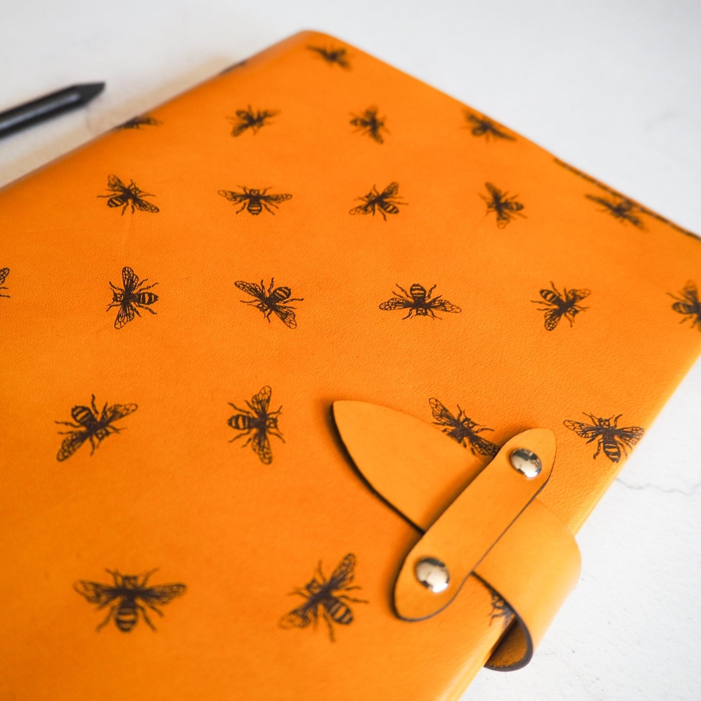Close up on the clasp and bee engraving on the Bee Journal.