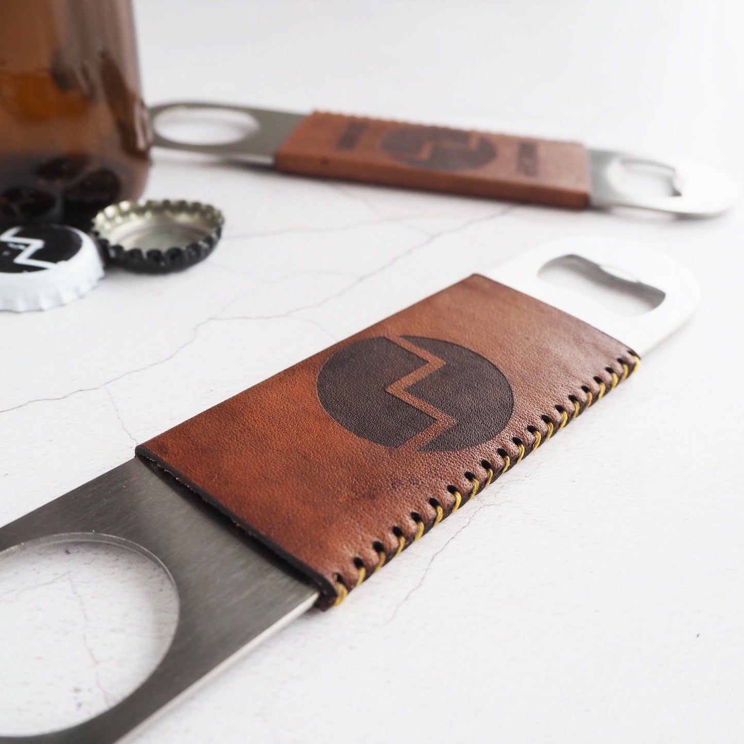 This personalised bottle opener has a leather slip case that has been hand dyed in medium brown and hand stitched in waxed linen thread.