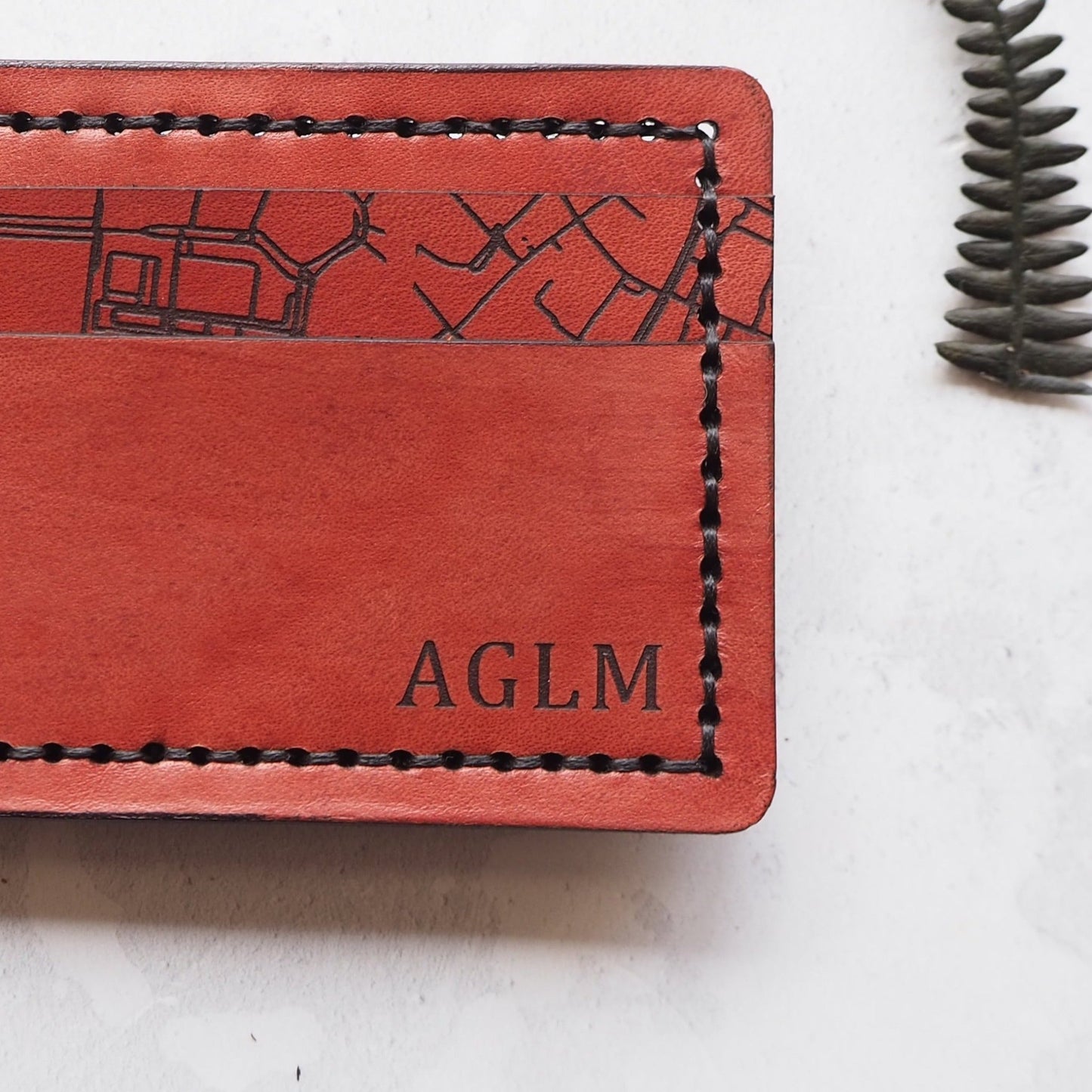 Closer look at the custom engraving of the initials and roadmap on the personalised card holder.