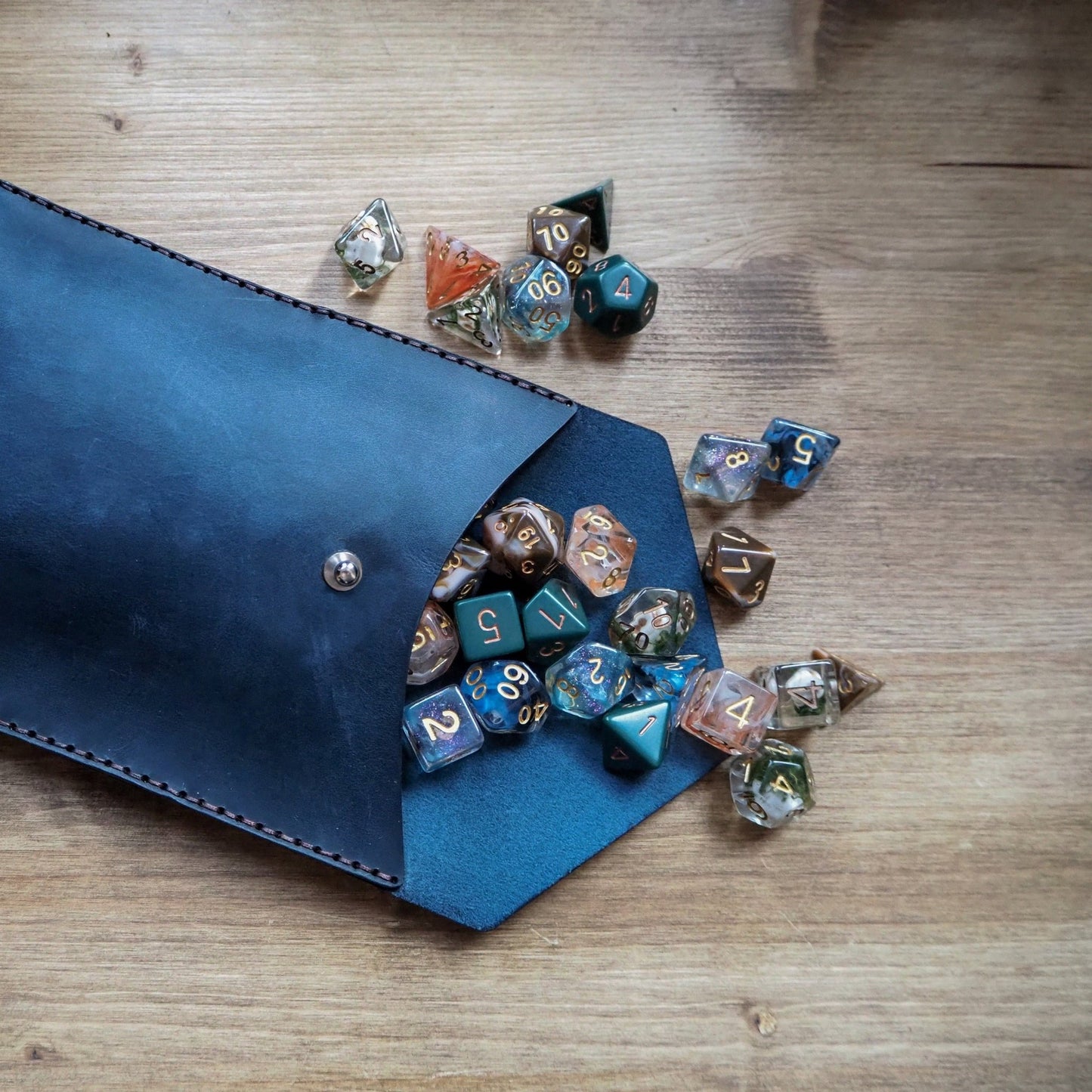 Hand dyed and hand stitched DnD dice pouch in blue colour with DnD dices.