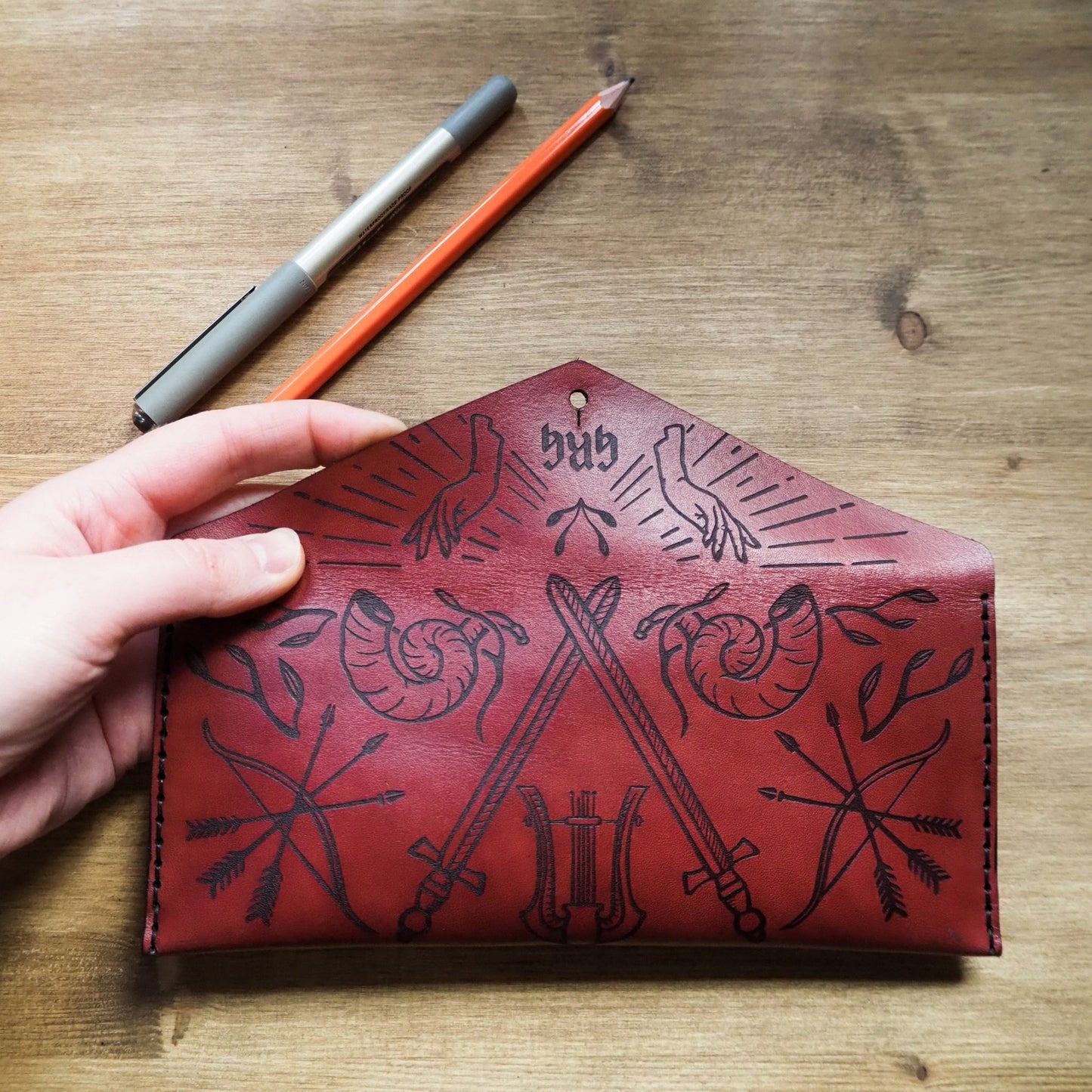 Back panel of the Dungeoneers Leather Pencil Case showcasing the engraving of symbols pertaining to adventure.