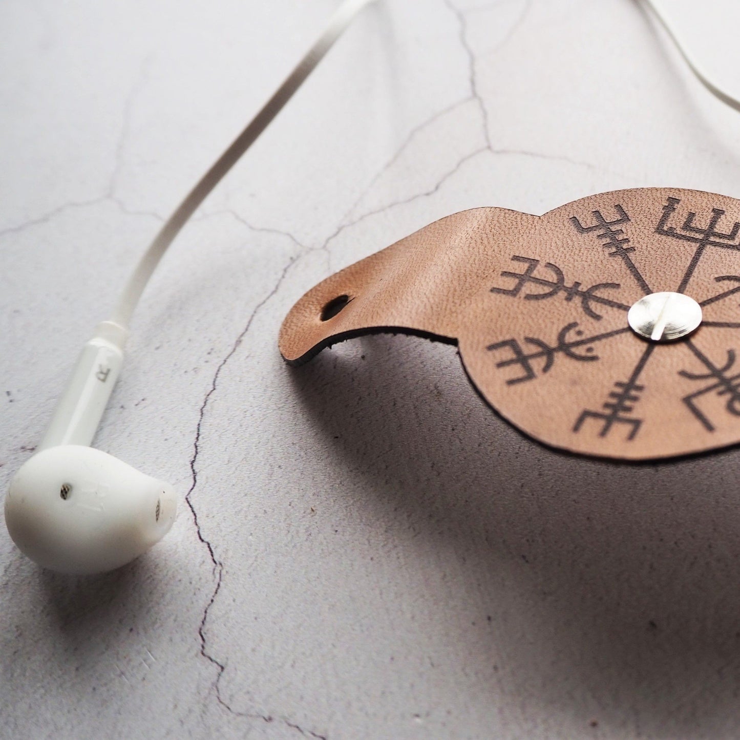 Closer view of the Vegivisr symbol engraved on the earphone cable holder by HÔRD.