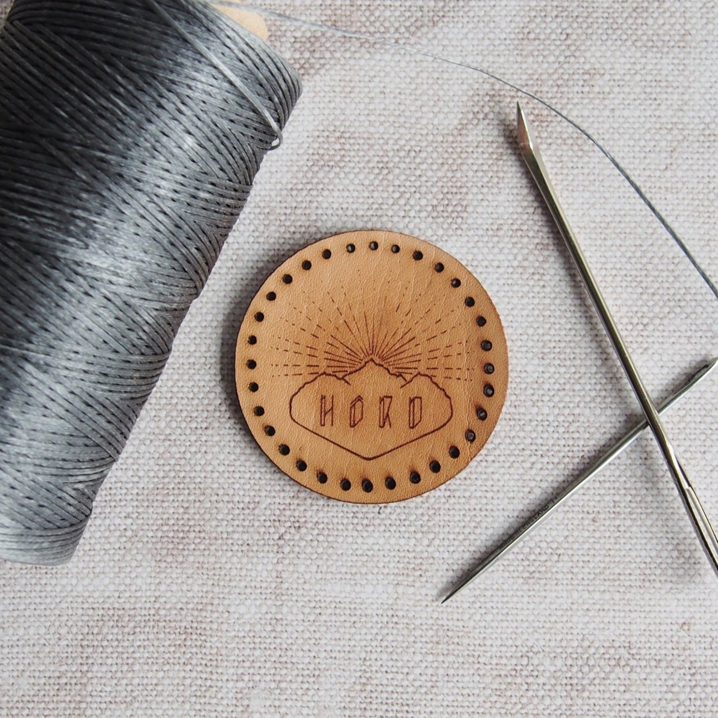 A circular leather patch engraved with the HORD logo so that you can represent your favourite leather brand - us! Stitch holes are ready cut to make sewing this onto your accessories super easy