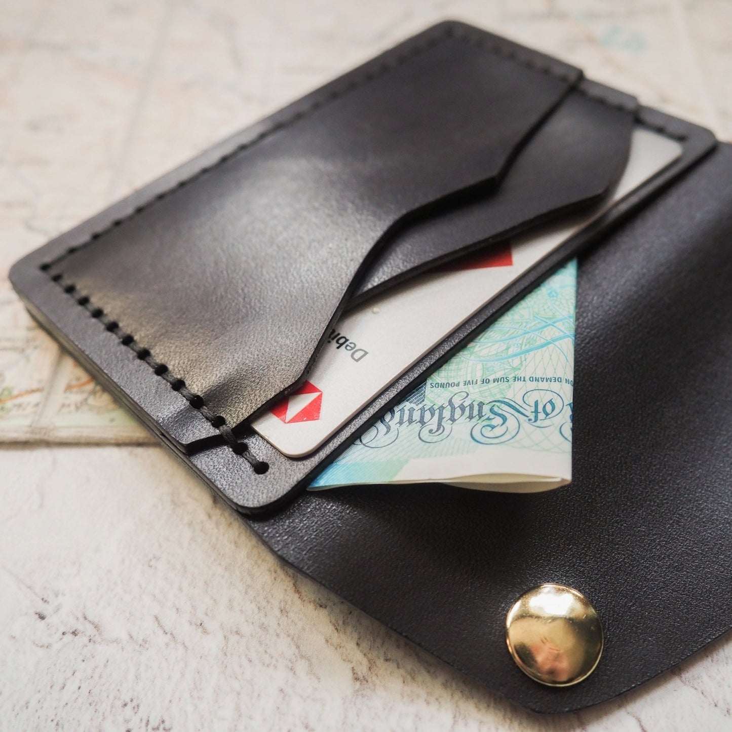 The Minimalist Wallet hand dyed in black leather colour and hand stitched with double waxed black linen thread.