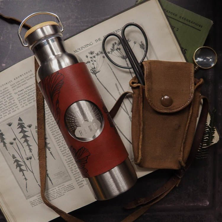 Mushroom Water Bottle - Stainless Steel 600ml. The leather wrap is engraved with a detailed illustration that explores the paterns of the frills of the splitgill mushroom. The leather wrap is dyed in burgundy. by Hord.
