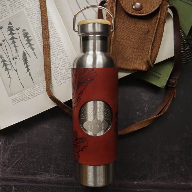 Mushroom Water Bottle - Stainless Steel 600ml. The leather wrap is engraved with a detailed illustration that explores the paterns of the frills of the splitgill mushroom. The leather wrap is dyed in burgundy. by Hord.