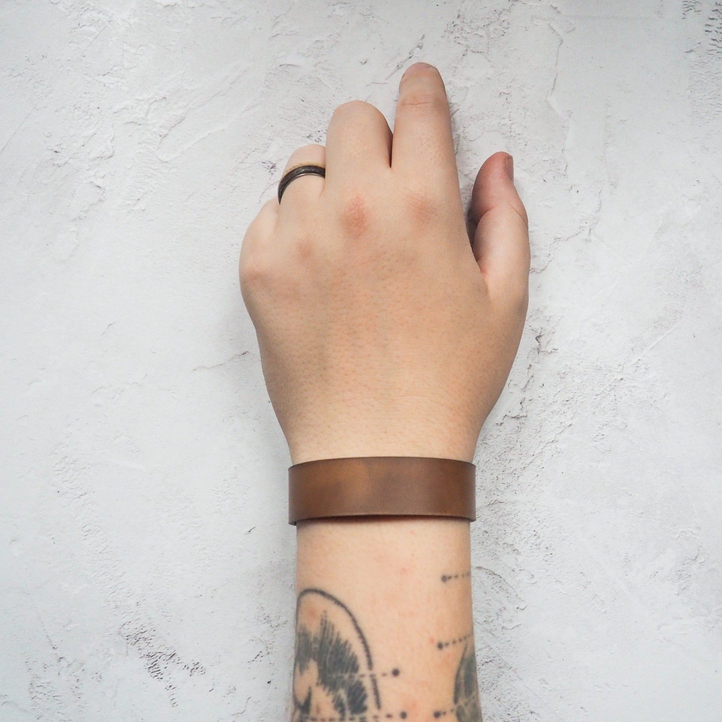 A person styled with a plain leather cuff bracelet, a leather bracelet from Hôrd.