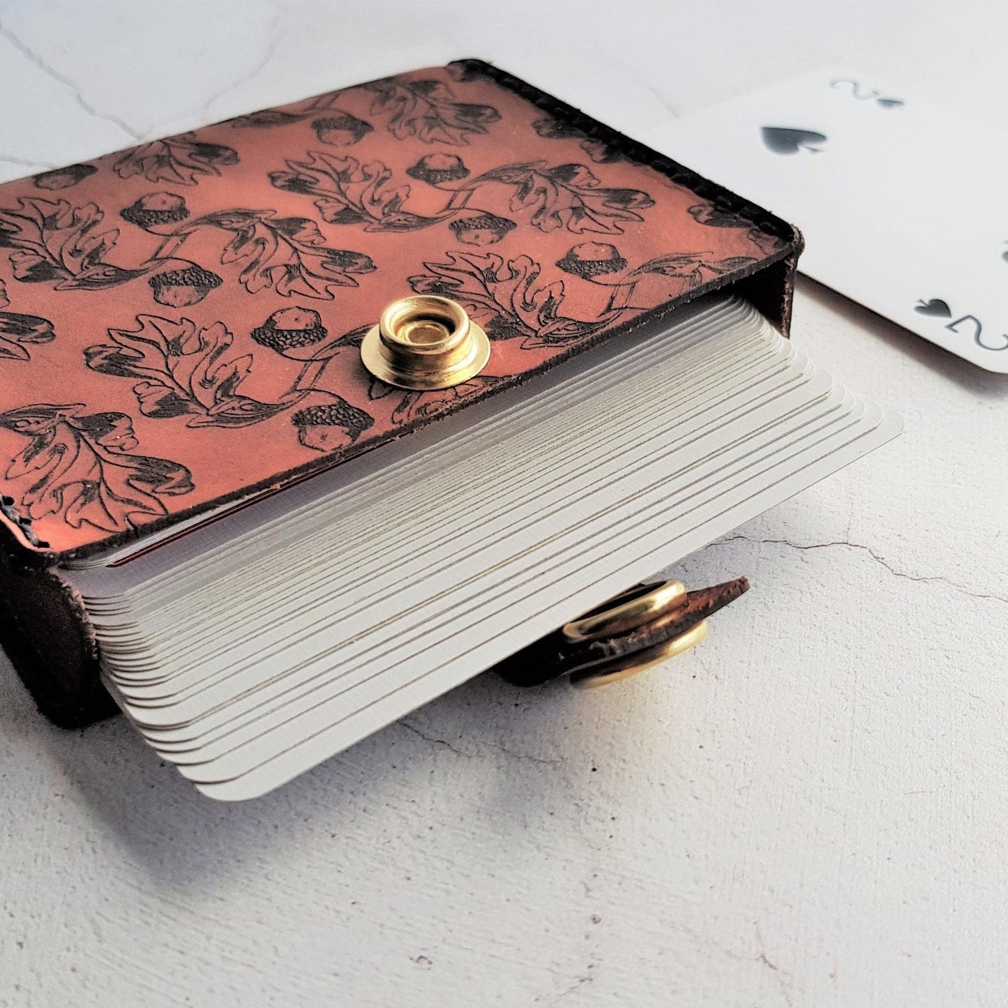 This Playing Card Case is engraved with a repeat pattern of acorns, perfect for keeping your deck of cards safe, a leather playing card case by HÔRD.