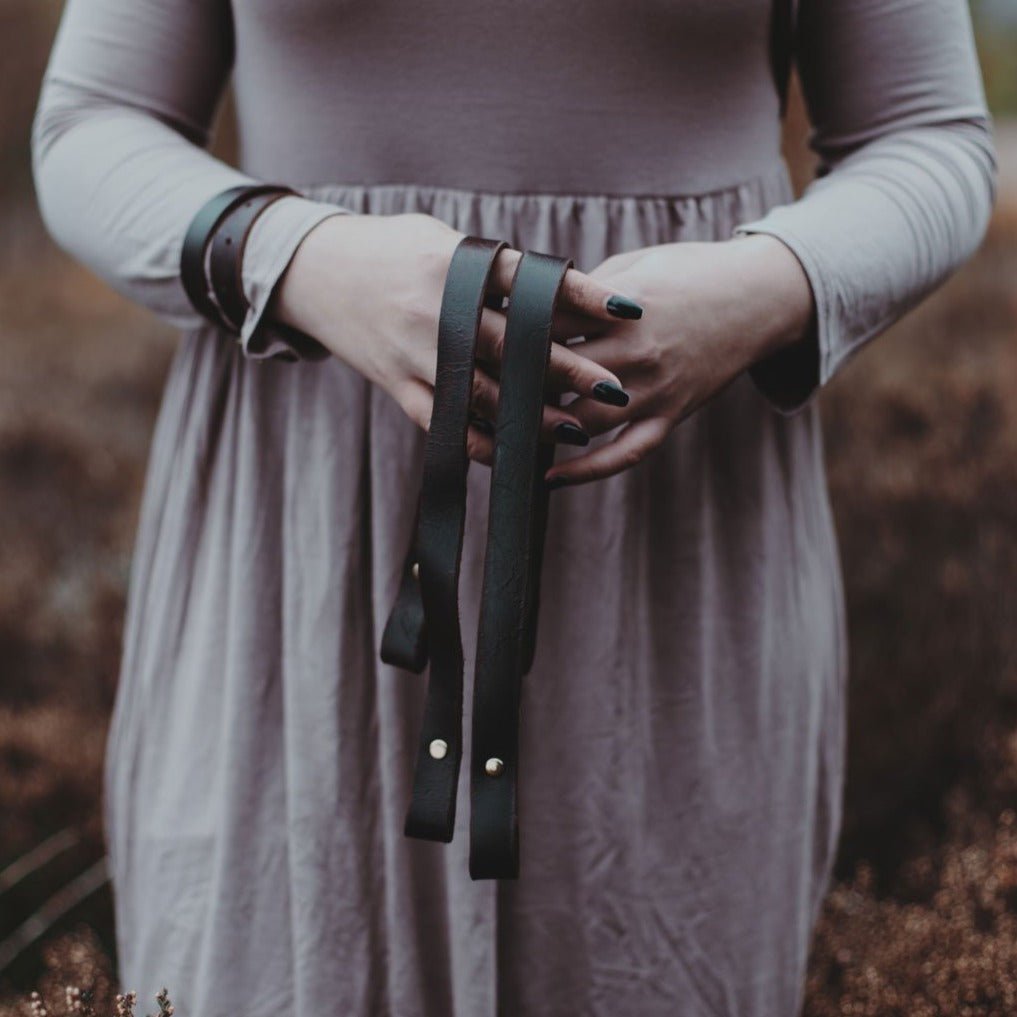 The leather shoulder harness being held by an individual.