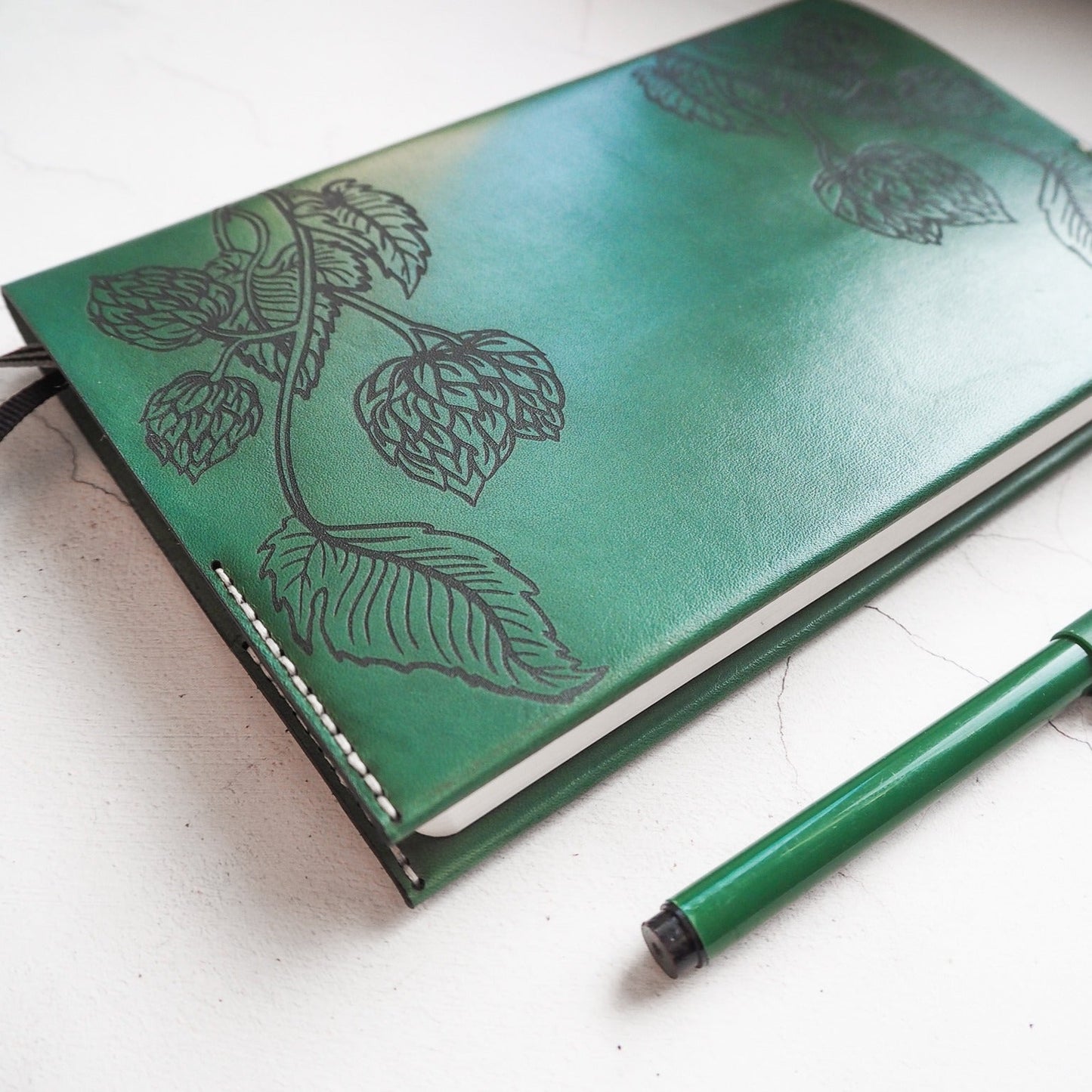 Engraving close-up view on the beer journal cover. The image features a green dyed beer journal.