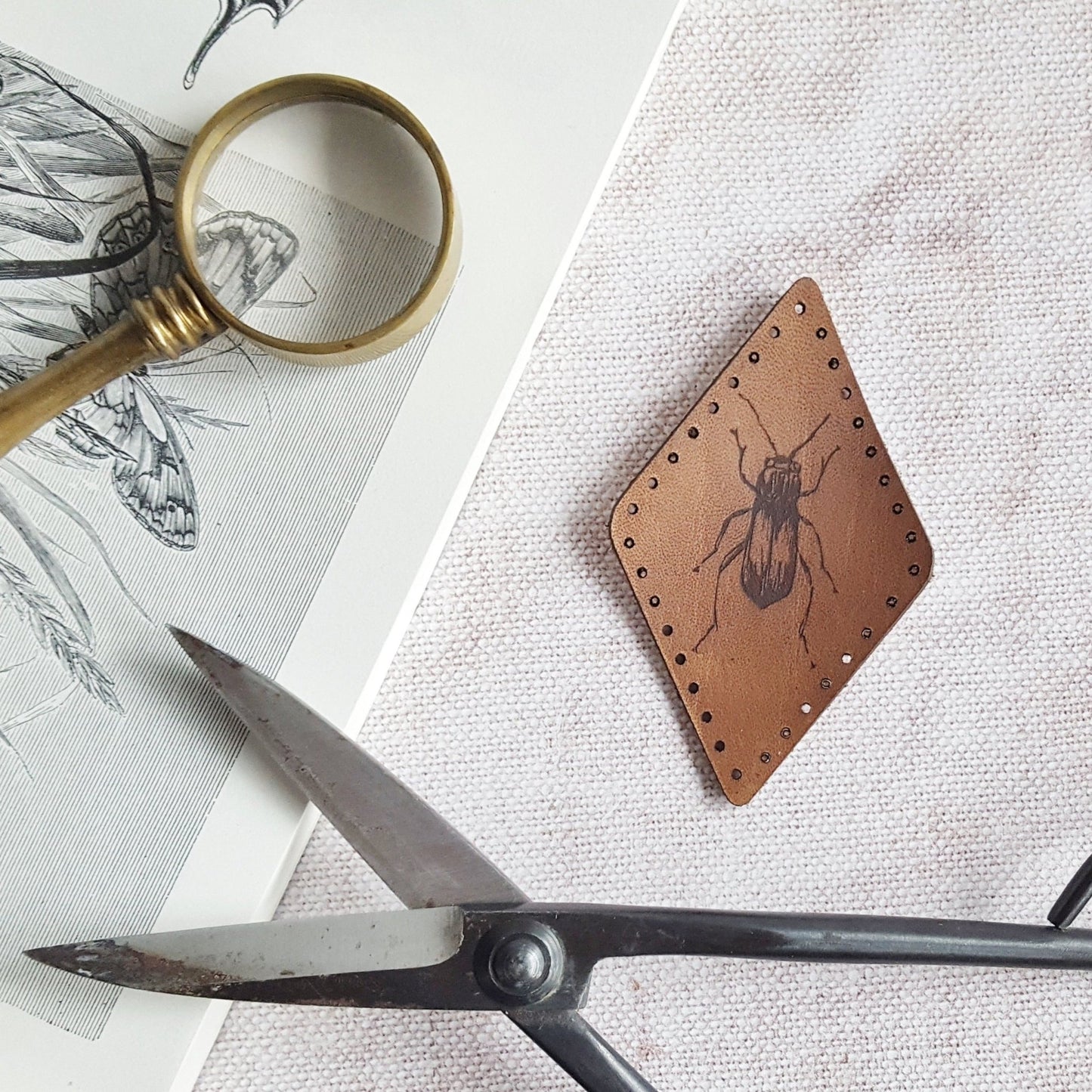 This diamond shaped patch is hand dyed a dark brown and engraved with an illustrative beetle, perfect for collectors. The beetle patch from Hord.