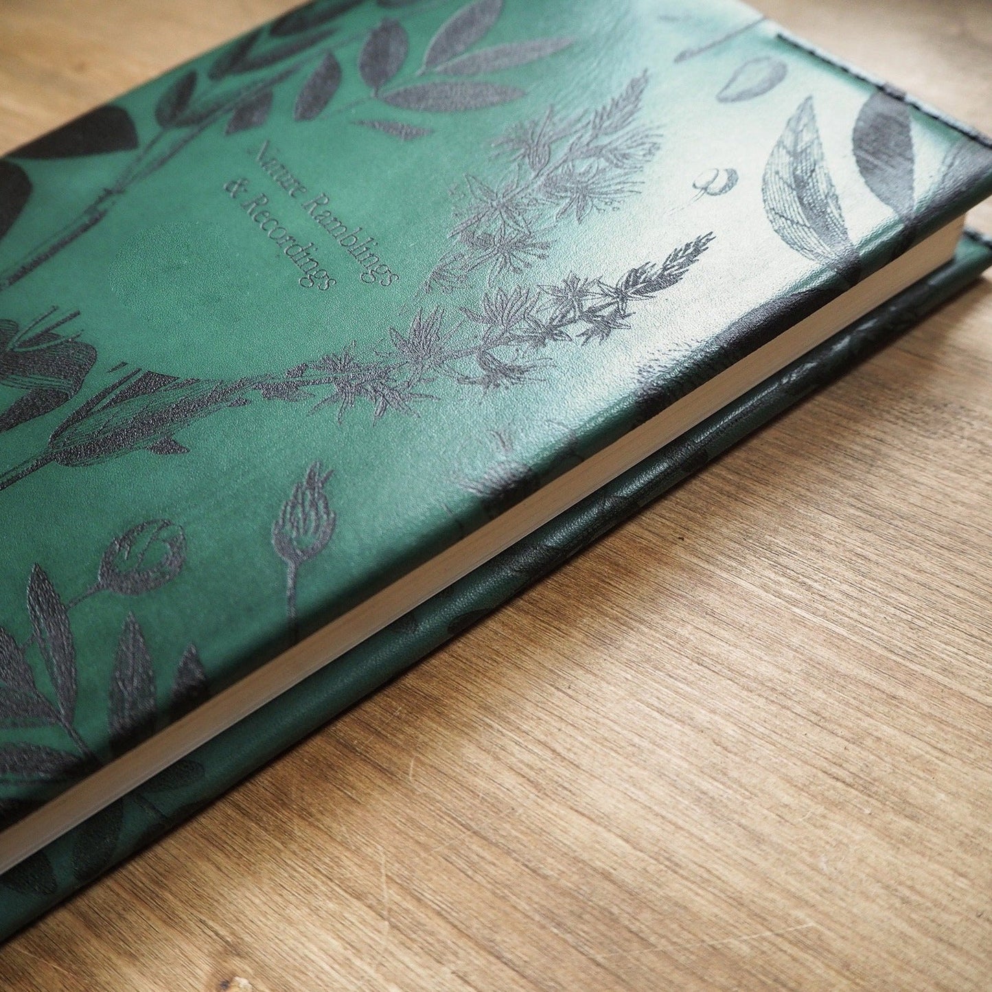 Close-up of the Garden Journal Cover showing the leaf and other nature-inspired engravings.