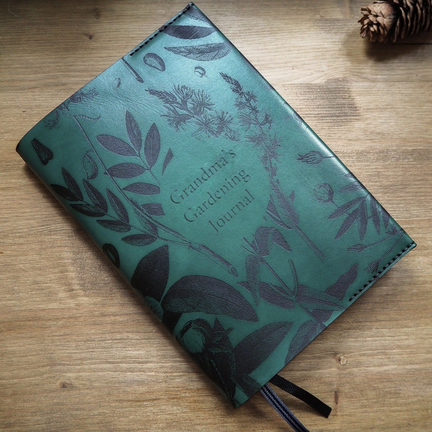 Green leather journal cover featuring Hôrd's botanical designs personalised with a custom text on the middle.