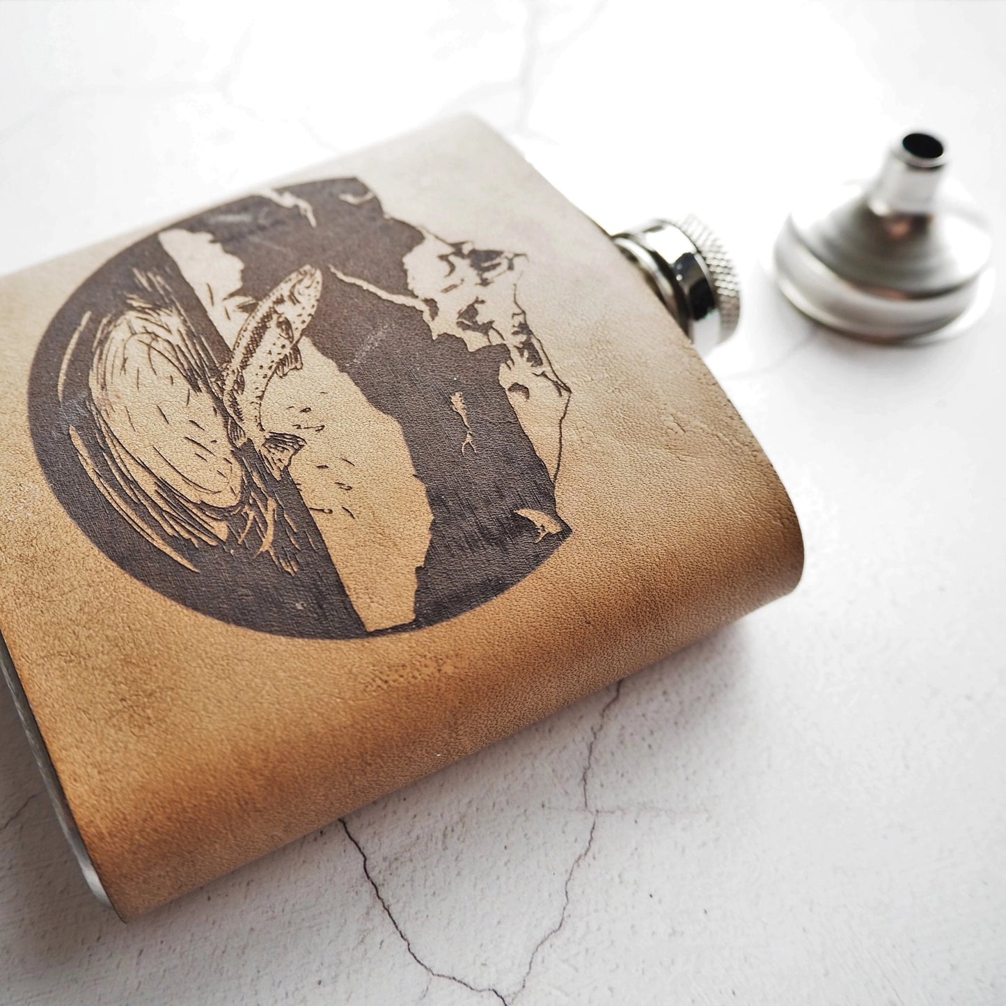 This fishing hip flask is made from high quality fill grain leather and clad onto a stainless steel flask.