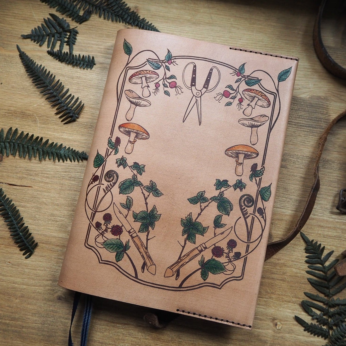 A hand painted leather cover for notebook featuring Hôrd's forager design.