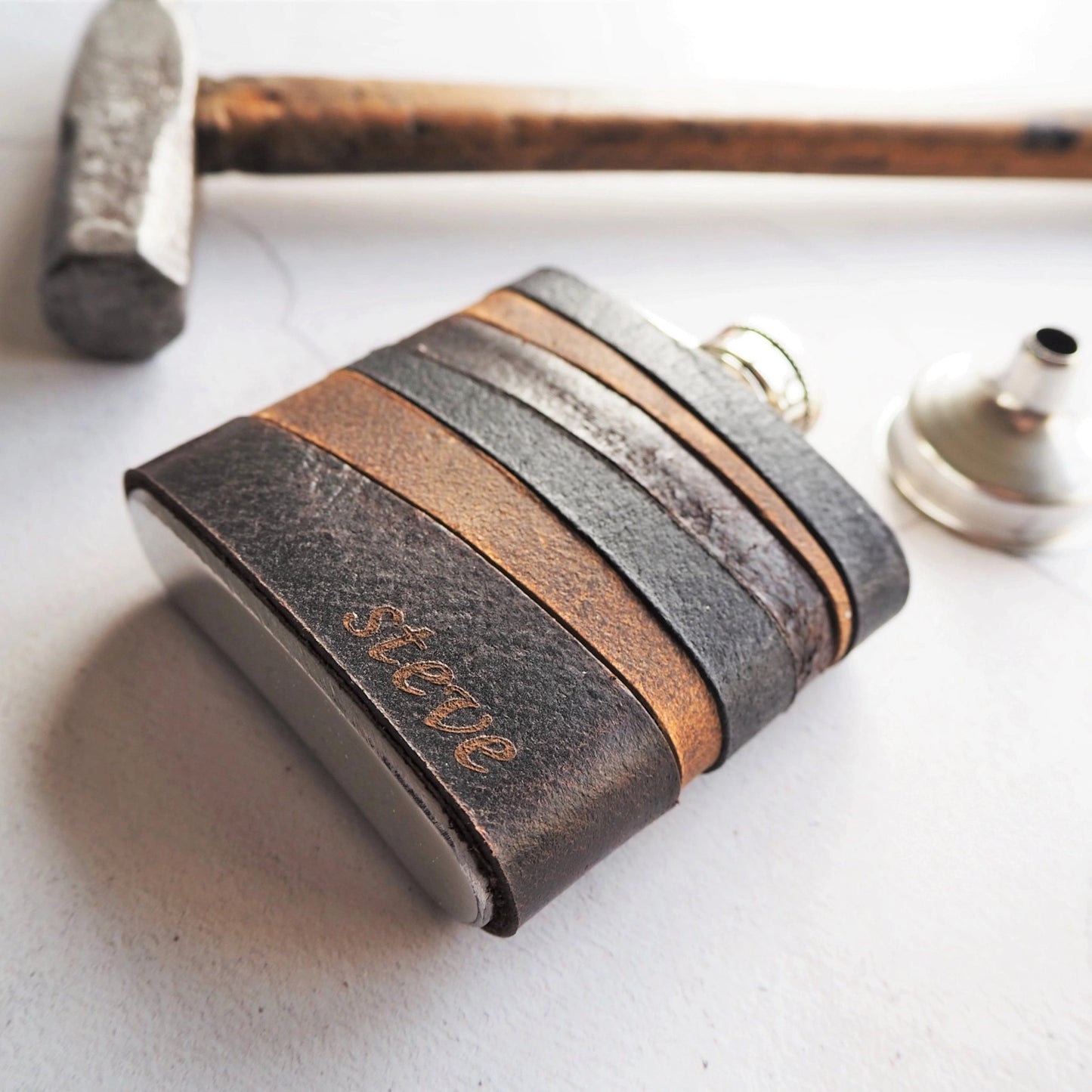 The Highland Vintage Leather Hip Flask is engraved with a name or initial on the bottom right corner of the flask.