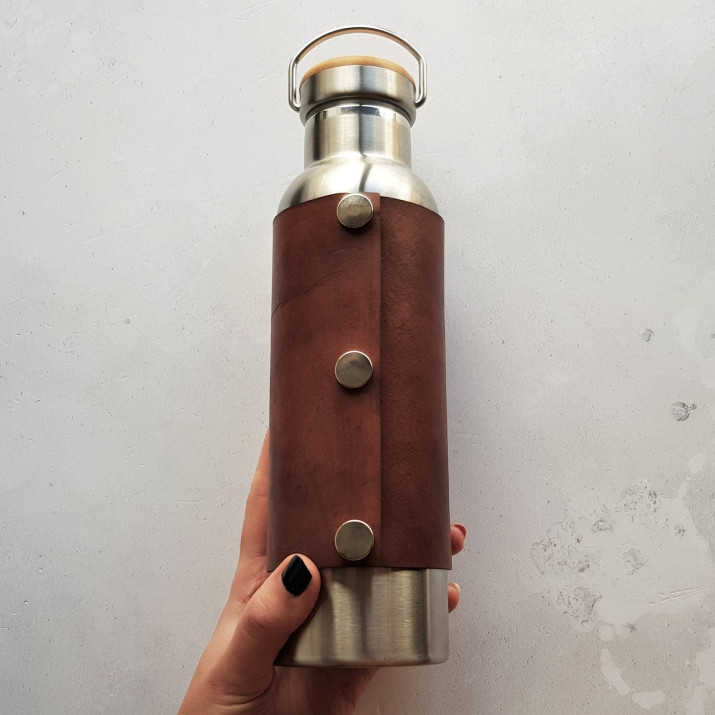 The back of the Personalised Insulated Water Bottle by HÔRD. The leather wrap is attached with 3 steel poppers. The bottle holds 600 ml and is BPA free.