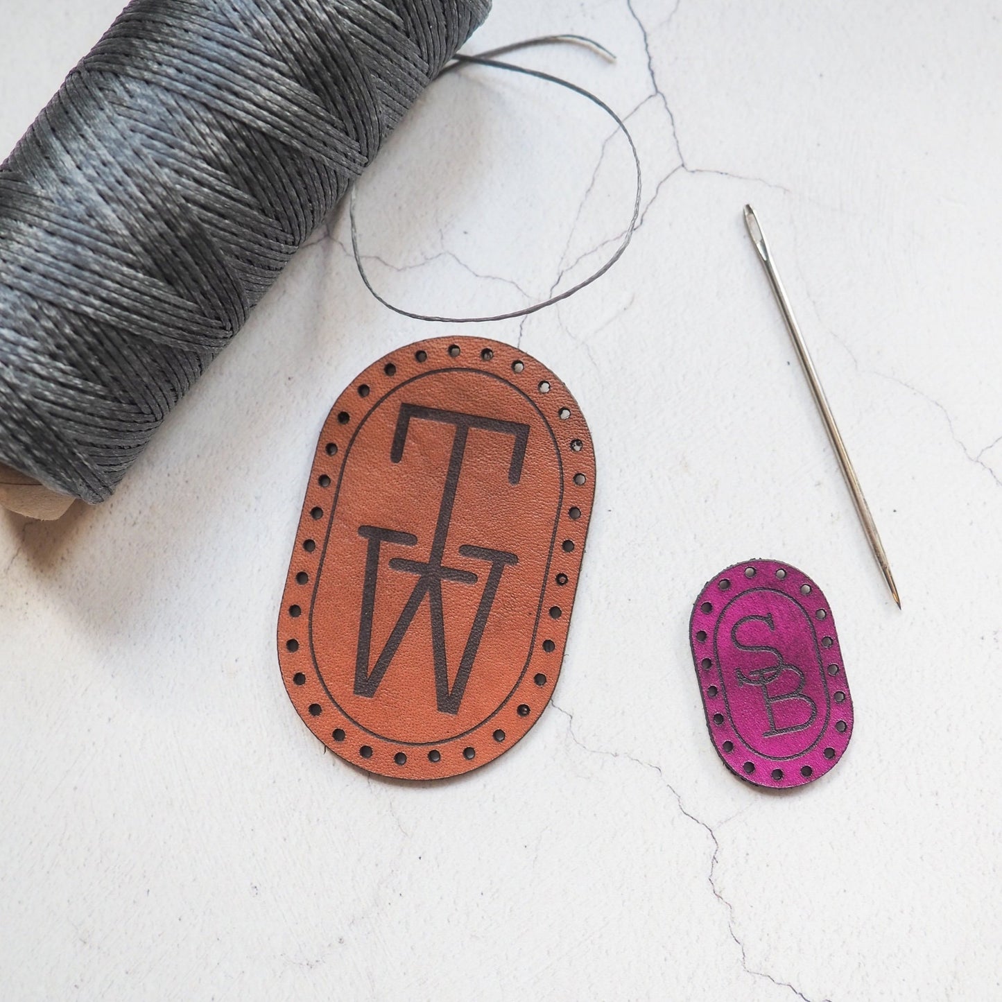 The monogrammed patch by hord. An oval leather patch engraved with two intersecting initials.