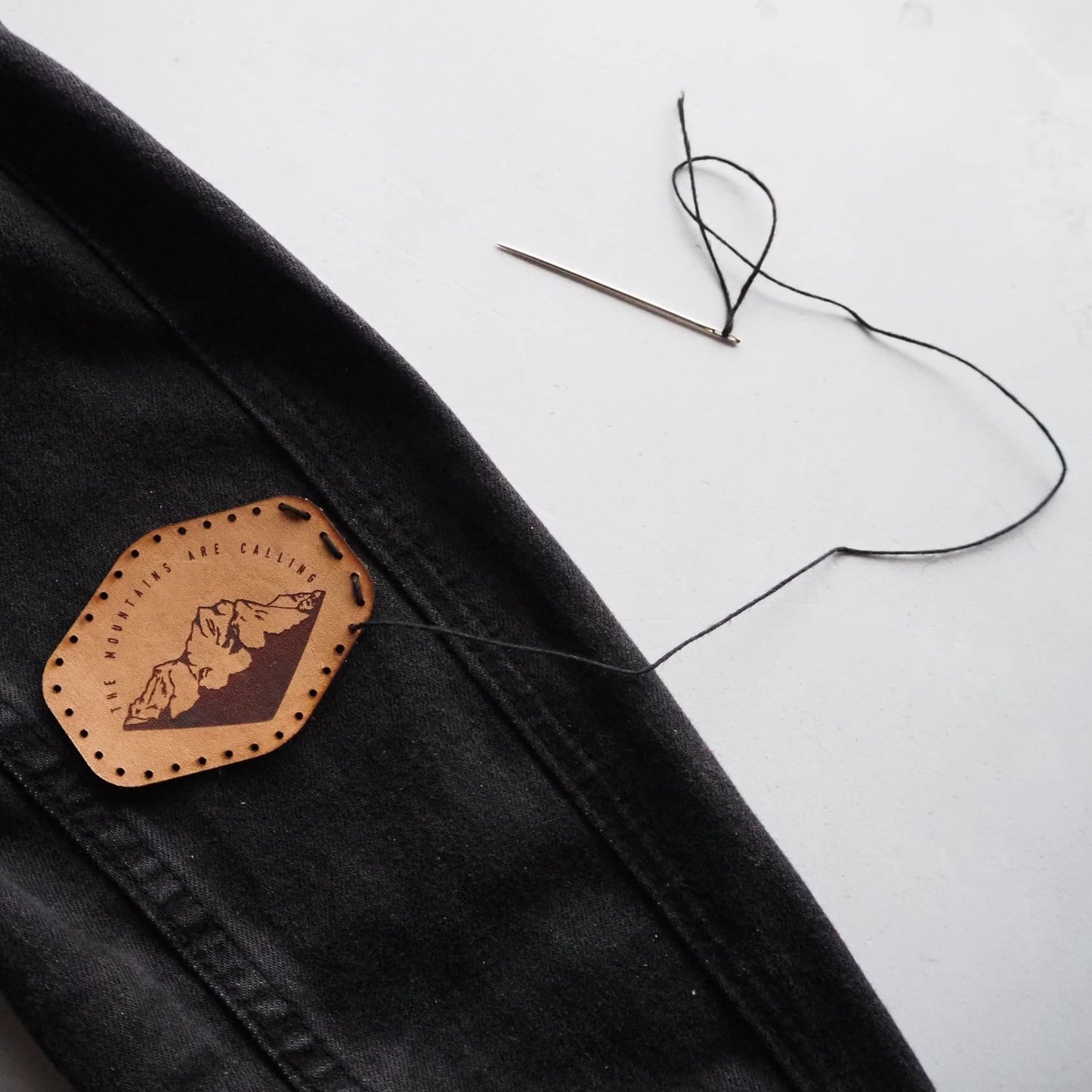 The Mountains Are Calling, Leather mountain Patch by HORD - This hand dyed leather patch is emblazoned with mountains and an inspirational quote. Pre cut stitch holes make this patch easy to sew and it will gain a lovely patina over time, gaining a more vintage look.