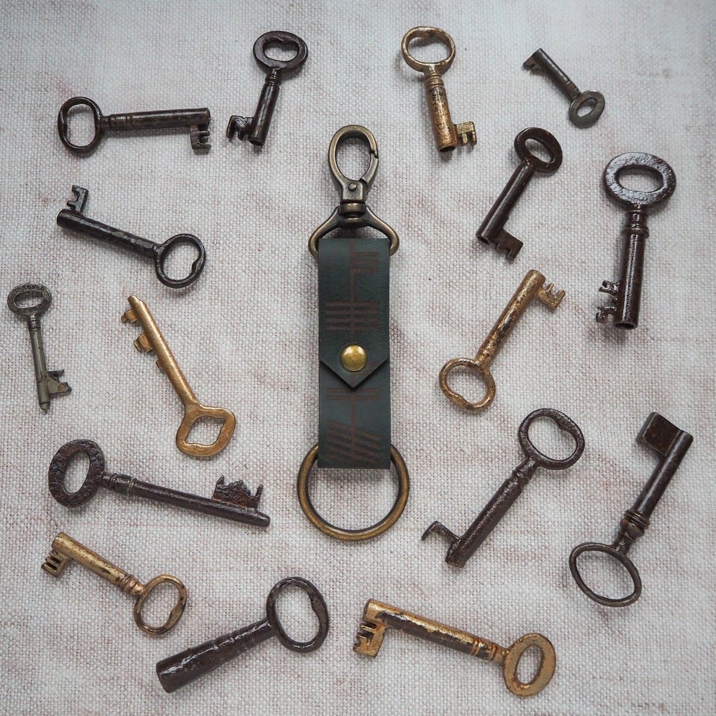 The Ogham Key Fob in green leather colour and antique brass hardware.
