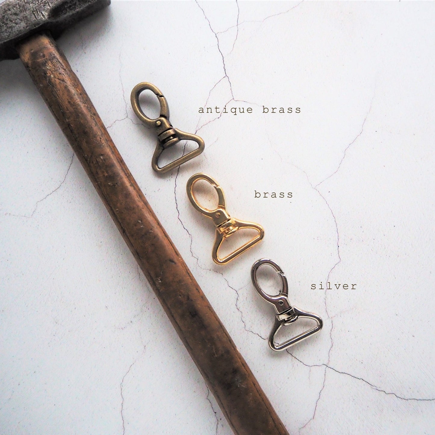 The three choices of hardware colour available for the leather keyring.