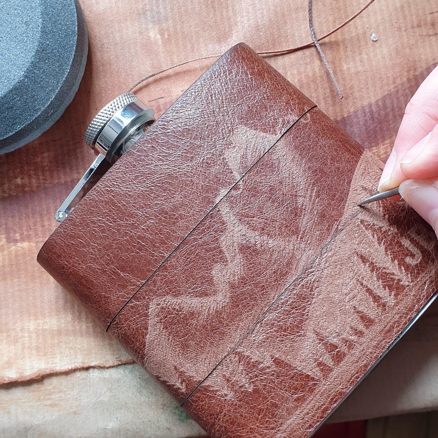 The outdoor hip flask being hand engraved.