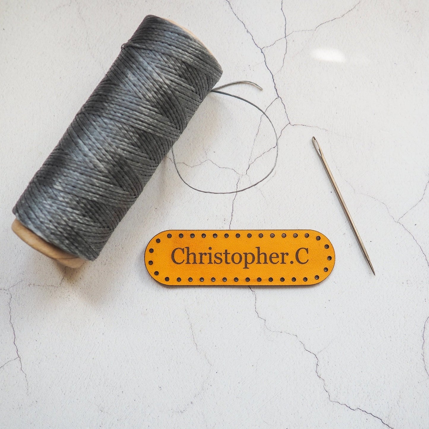 This personalised leather patch has been hand dyed and engraved with a custom name.