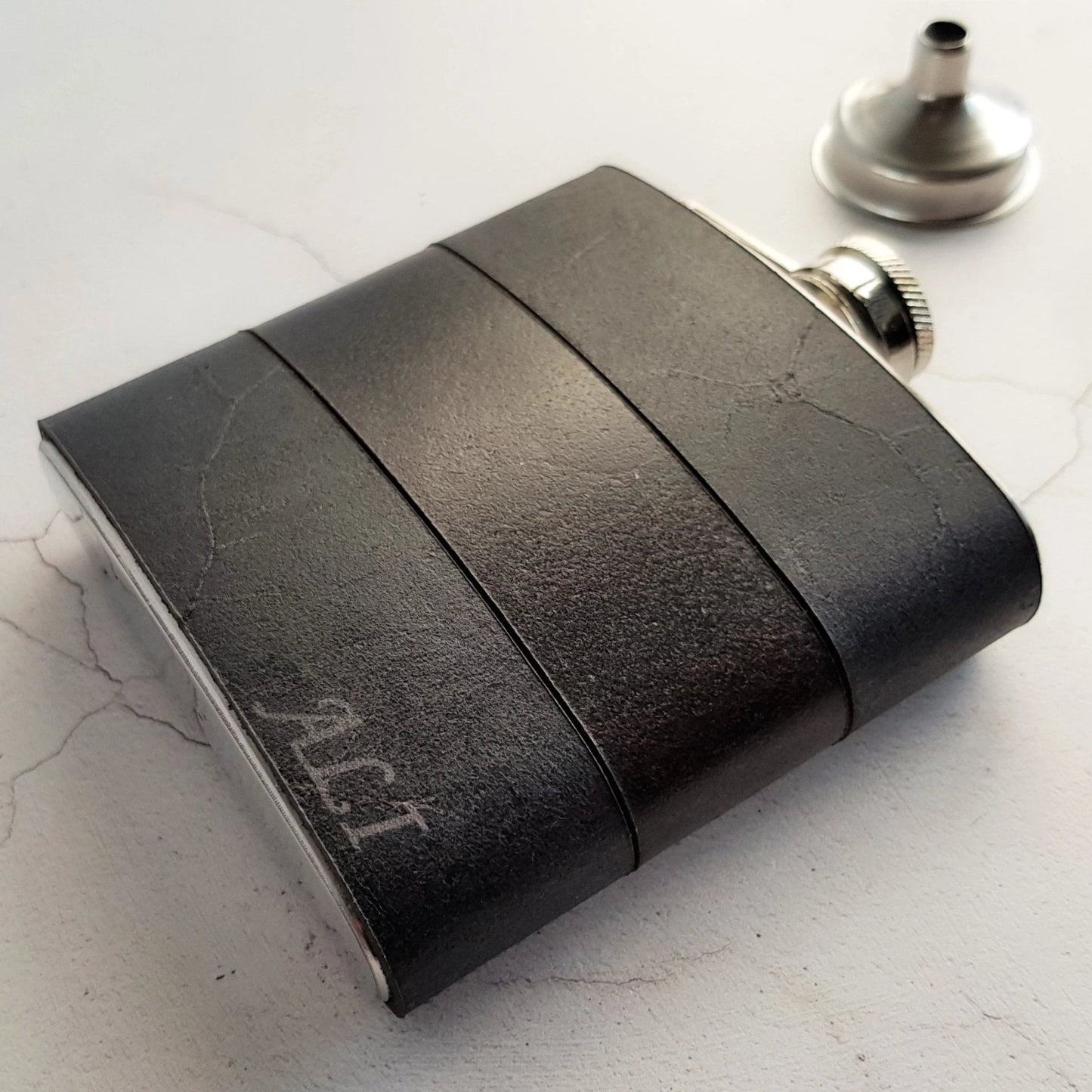 The Smoke and Peat Leather Flask is engraved with a custom name.