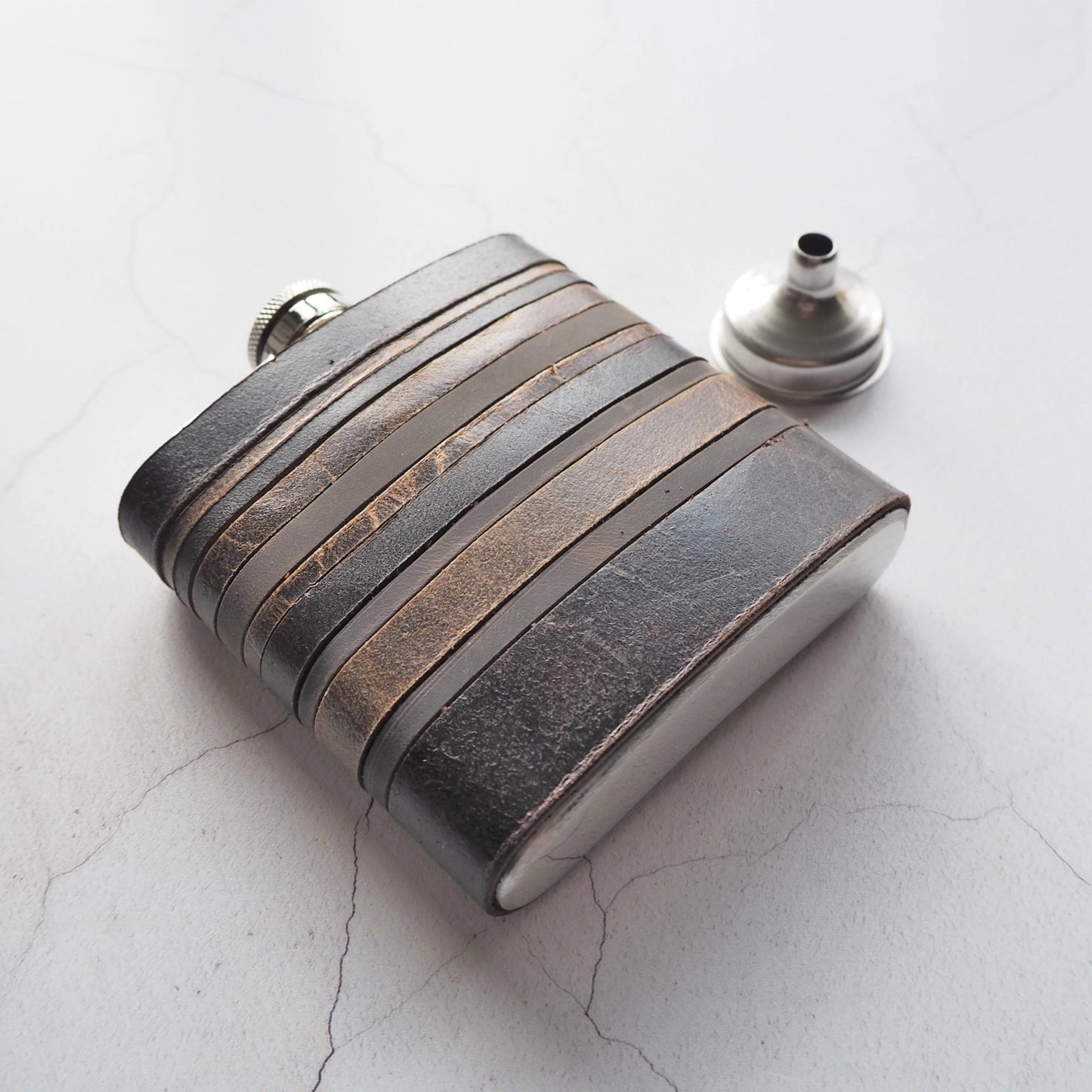 This vintage hip flask is handcrafted from leather remnants and could be personalised with a name or initial.