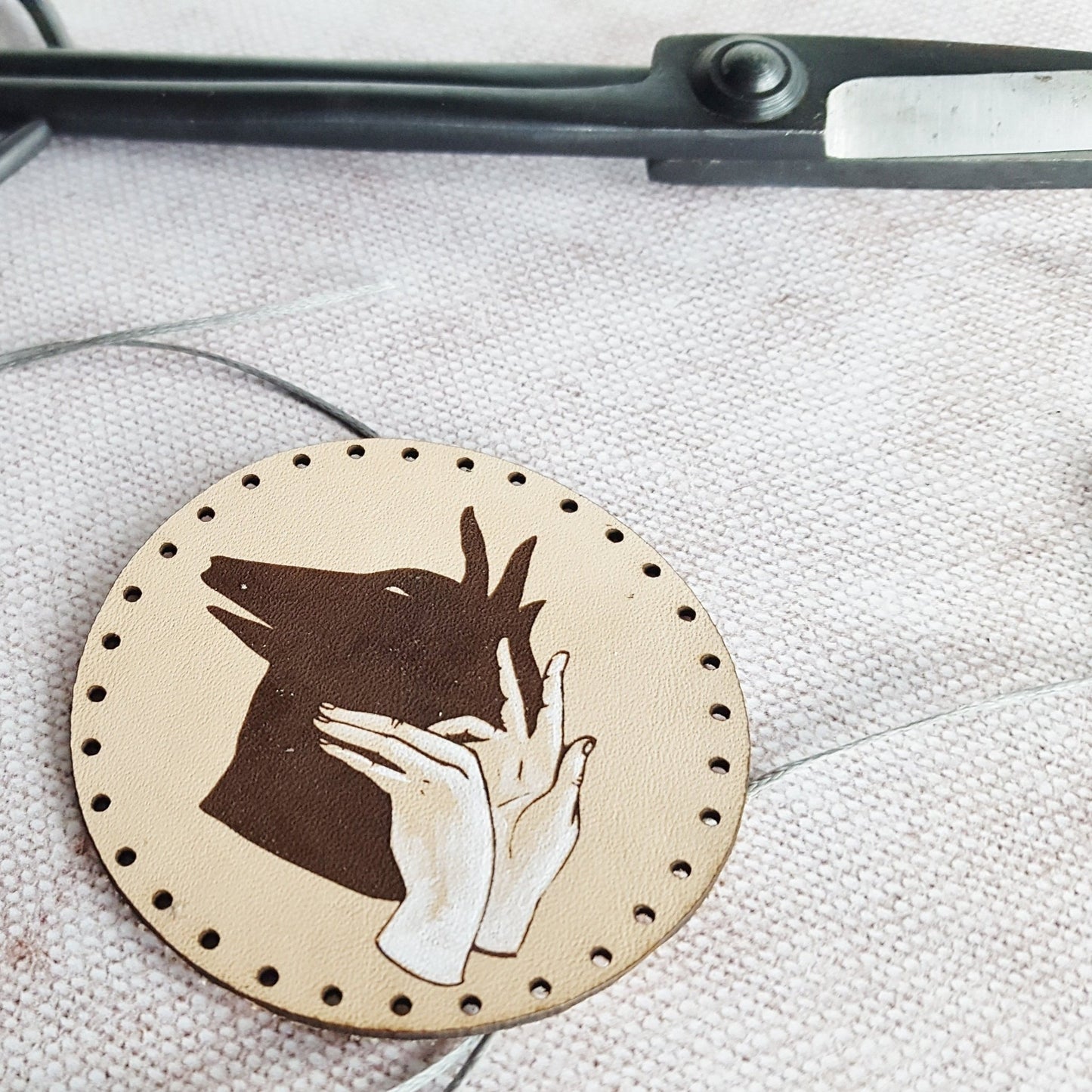 The Wolf Patch by HORD - a hand painted illustrative leather patch, reminiscent of those nights out camping when we would make shadow puppets against the side of the tent with our torch.