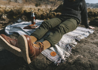  A man sits on a picnic blanket