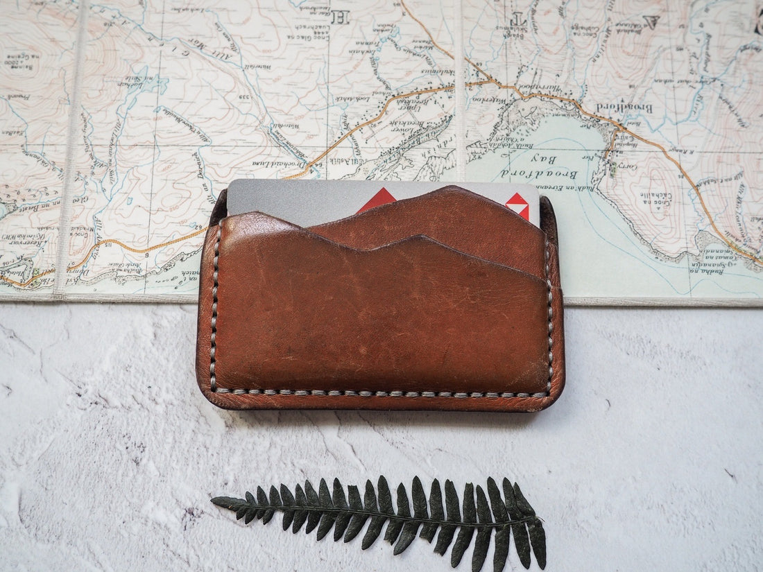  A five year old card holder , in medium brown dye with grey stitch. This piece is the prototype of our original mountain card holder. 