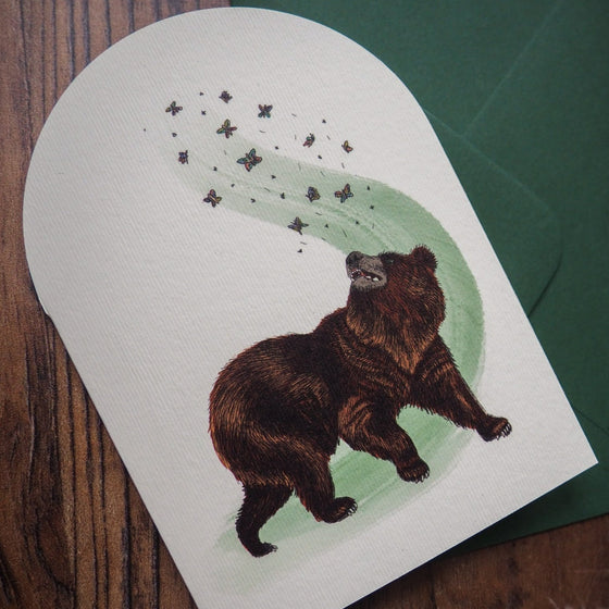 Illustrated bear and butterfly design on a charming greeting card.
