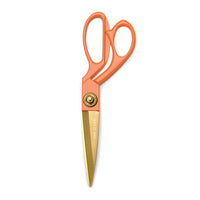 Orange-handled scissors with gold blades on a white background