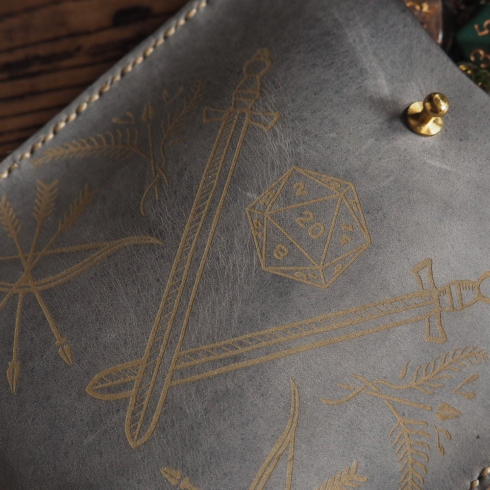 
                  
                    Grey Leather Dice Pouch engraved with swords, a d20 and bow
                  
                
