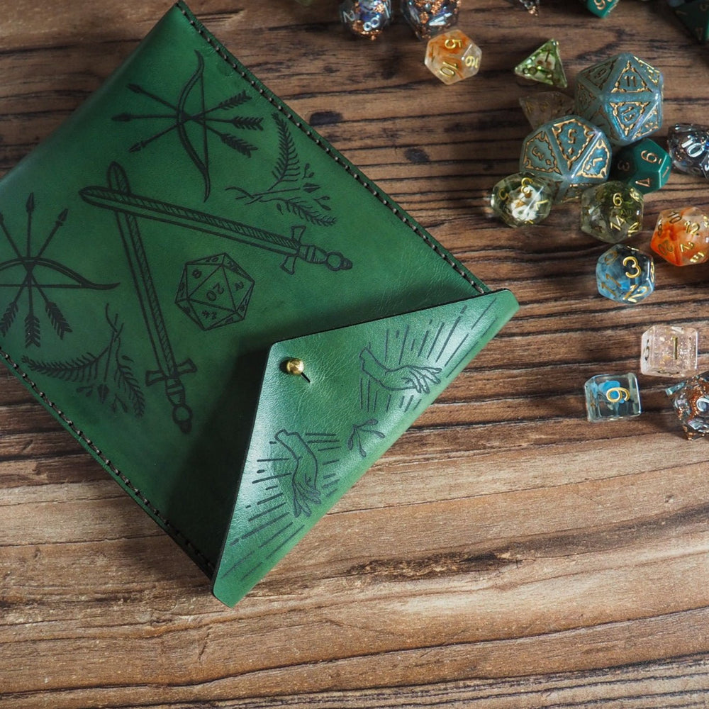 
                  
                    Green leather dice pouch with embossed designs on a wooden surface with colorful dice.
                  
                