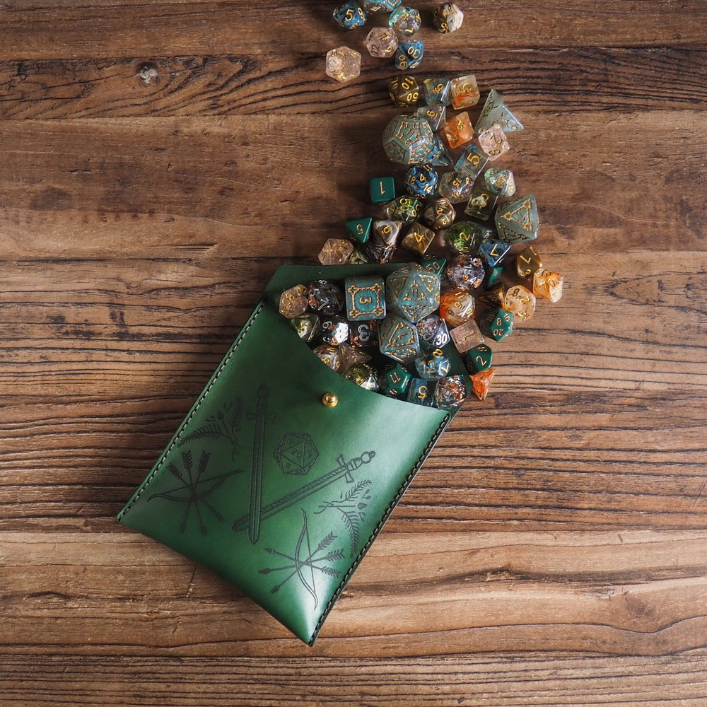 
                  
                    Green leather pouch with decorative patterns filled with colorful dice on a wooden surface
                  
                