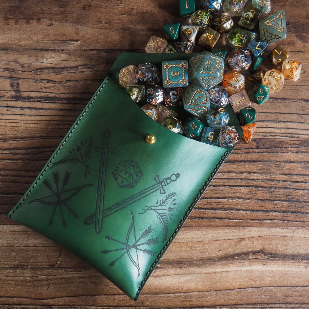 
                  
                    Green leather pouch with engraved design on a wooden surface with dice
                  
                