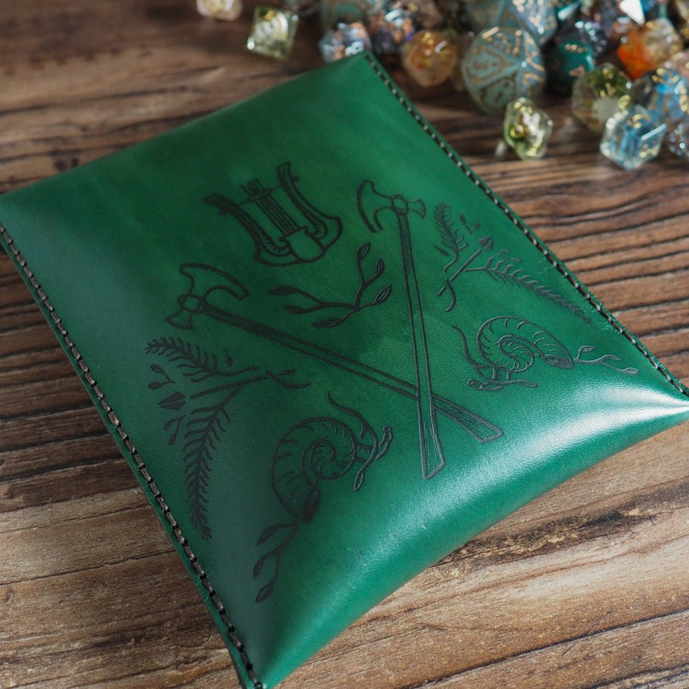 
                  
                    Green leather pouch with embossed design on a wooden surface
                  
                