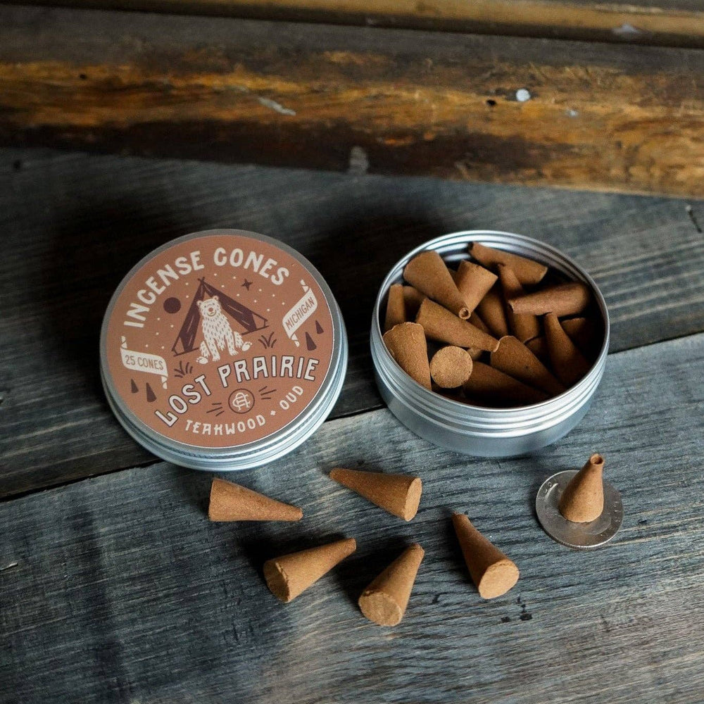 
                  
                    Cones and a container labeled 'Lost Prairie' on a wooden surface
                  
                