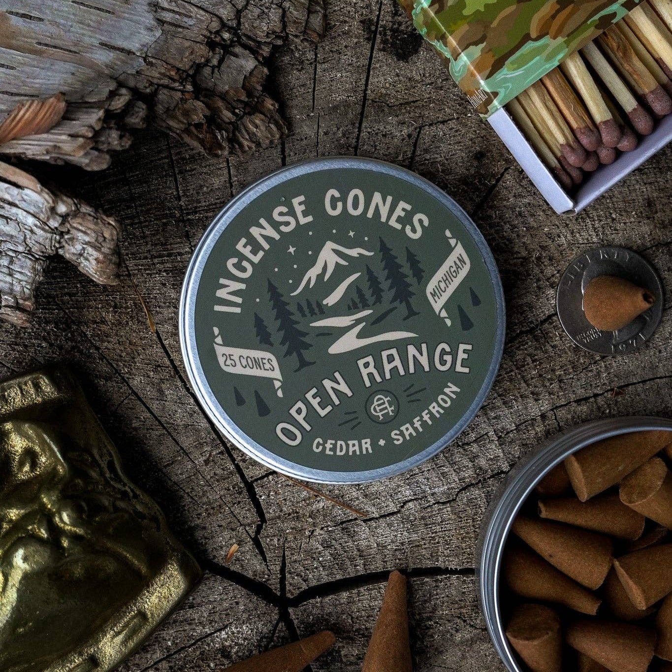 Incense cones container labeled 'Open Range' on a wooden surface with incense cones and matches.