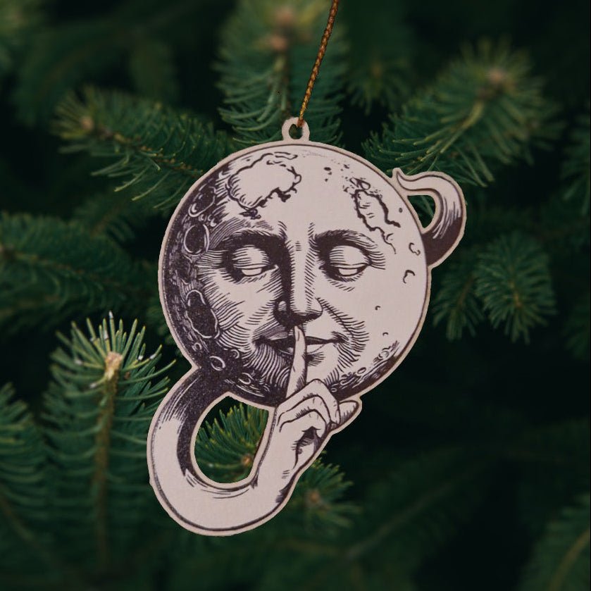 Decorative ornament with celestial design on a green pine branch