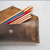 The Brown Leather Pencil Case filled with pencils and paint brushes.
