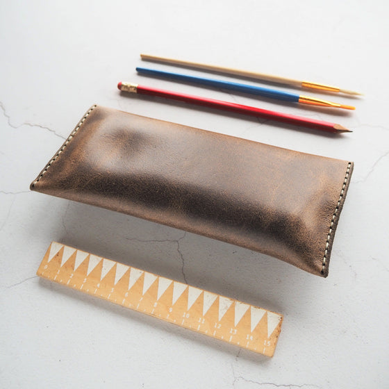 A brown leather pencil case that has been hand stitched with double waxed linen thread for longevity.