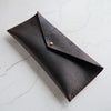 The Dark Leather Pencil Case that has been fastened with a stud.