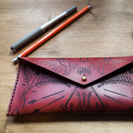 The Dungeoneers Leather Pencil Case that has been hand dyed in bordeaux and and hand-stitched with black waxed linen thread. 
