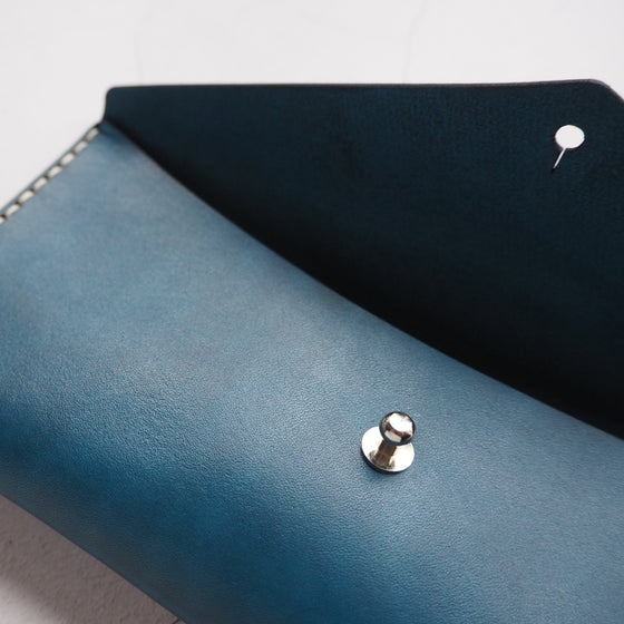 The Dyed Leather Pencil Case has a stud to keep all your essentials safe and secure.